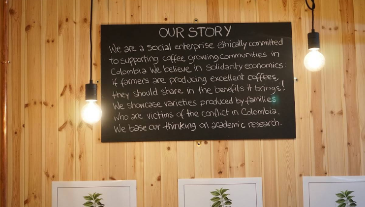 Inside The Colombian Coffee Co., a chalkboard displays 'Our Story'