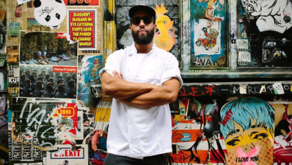 James Cochrane stands, owner and head chef at Islingston’s 12:51 restaurant, stands in his chefs apron, a cap and sunglasses with his arms folded, in front of a colourfully-graffitied wall