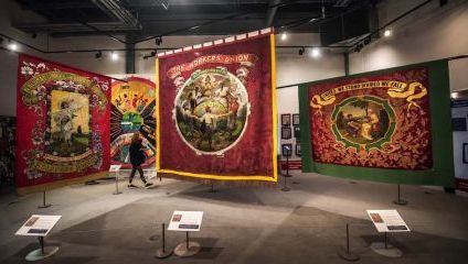 Inside the people's history museum. 4 Large hanging banners Workers Union flags in red and green