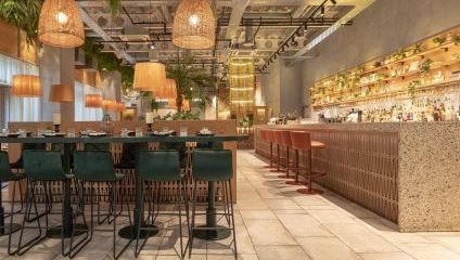 Inside firefly restaurant - white interior, long bar and green bar stools, basket weave lampshades