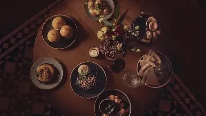 Aerial shot of Lots of meat dishes on a dark wooden table