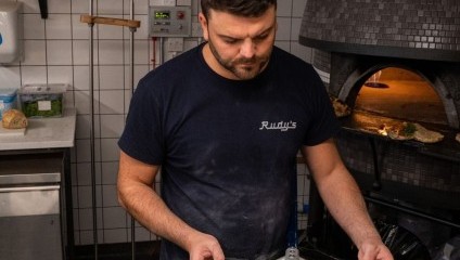 Man making a tomato and cheese pizza