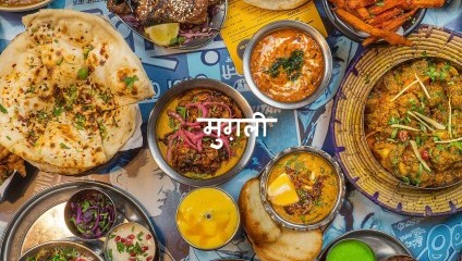 Lots of coloured rice, curry and side dishes in oriental colourful bowls and plates