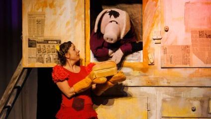 A lady in a red dress talking to a man in a pig costume