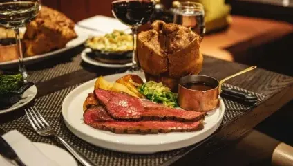 Sunday roast with rare beef, large Yorkshire pudding and vegetables