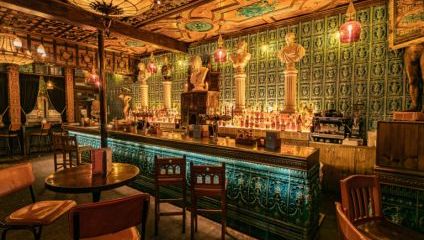 Inside the Queens Head pub, Islington. Green tiled back wall with tiled turquise bar, Victorian engraving and lighting