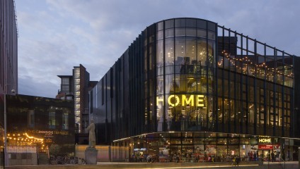 Outside shot of HOME events space. Glass fronted with yellow HOME sign against a grey sky.