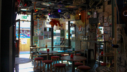 Quirky independent and accessible café-bar in Brighton with graffiti-covered walls, mismatched vintage furniture, and maximalist decoration.