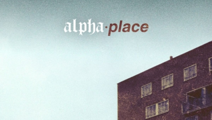 A tall, dark residential building with multiple windows is on the right side of the image, while the left side shows a soft blue sky. The text alpha place is written at the top, with alpha in a white font and place in a red font.