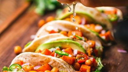 soft tortillas with filling and small black bowl with colourful vegetables