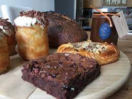 five cakes on a white plate - a pain au chocolate, chocolate brownie and 3 others.