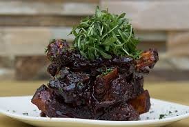 Stack of chargrilled ribs with green rocket leaves on top