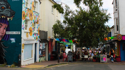 Crowds enjoying a meal outside of La Choza, Gloucester Road, with colourful bunting and street-art views.