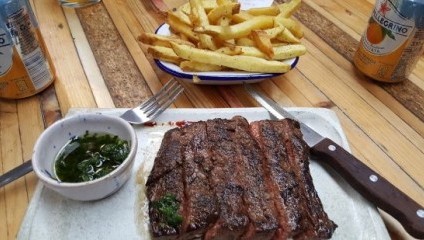 Steak, chips, green salad, beer and knife and fork