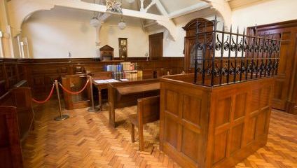 Mock-up of a wooden court room complete with docks and judges bench