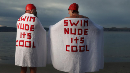 two swimmers naked with towels on saying its cool to swim naked