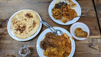 3 white bowls each with curry in and white flatbread at the side