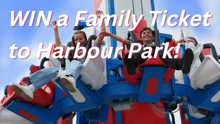 Two smiling children with raised hands enjoy a ride on an amusement park ride. Text over the image reads: WIN a Family Ticket to Harbour Park! The background shows a blue sky with some scattered clouds.