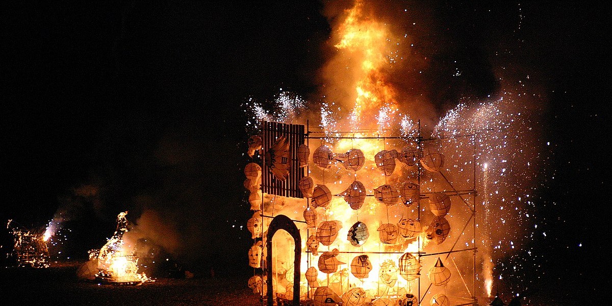 A fiery, glowing moment from Brighton’s Burning the Clocks festival, featured as part of the city’s Christmas and winter season celebrations. Handmade lanterns melt in the blaze of a large sculpture by the sea, fireworks erupting in the dark sky - a striking highlight of Brighton Christmas events, lantern parades, and community winter festivities.
