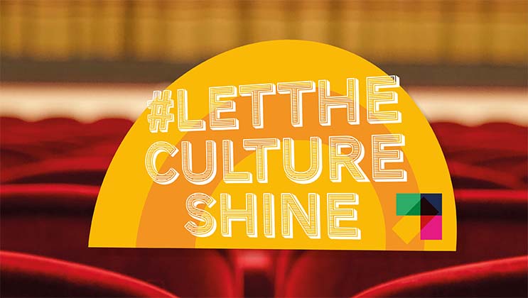 Yellow semi-circle with the hashtags #LetTheCultureShine and a colorful geometric shape over a blurred background of red theater seats and curtains, promoting cultural events.
