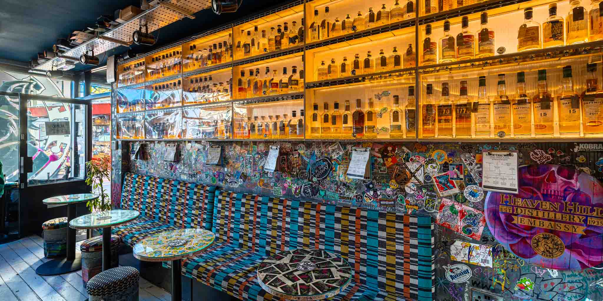 Graffiti-covered walls, cushioned seating and dozens of bottles of whiskey in a warmly lit cabinet.