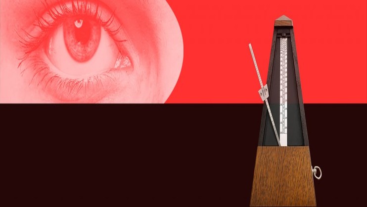 A red-tinted close-up of an eye is juxtaposed with a wooden metronome against a divided red and black background. The eye is on the left, while the metronome, with its pendulum, is placed on the right side of the image.