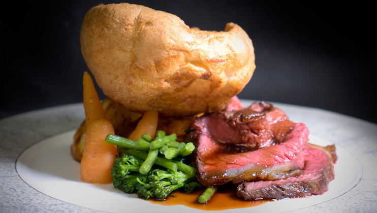 A plate a roast beef dinner with Yorkshire pudding and greens from the Lowry Hotel's The River Restaurant