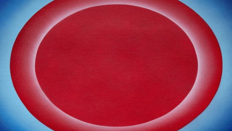 Abstract artwork featuring a large red oval centrally placed, with a gradient blue background. The oval has a soft glowing effect around its edges, creating a smooth transition between the red and blue hues.