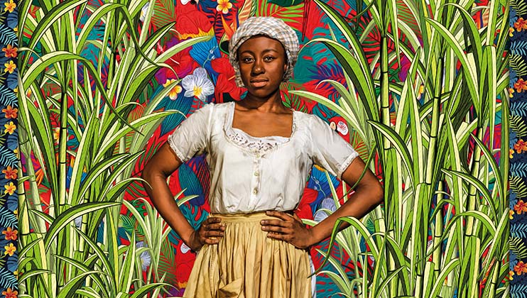 A person stands confidently with hands on hips, wearing a white blouse and a beige skirt. They wear a patterned headscarf. The vibrant background is filled with tropical foliage and flowers, creating a lively and colorful atmosphere.