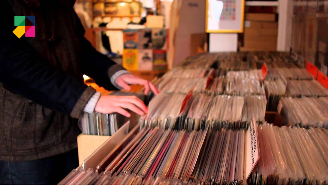A close up of a persons hands flipping through a box full of records at one of the many record shops in Brighton