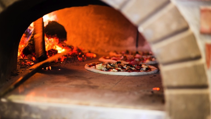Fresh pizza in a clay pizza oven