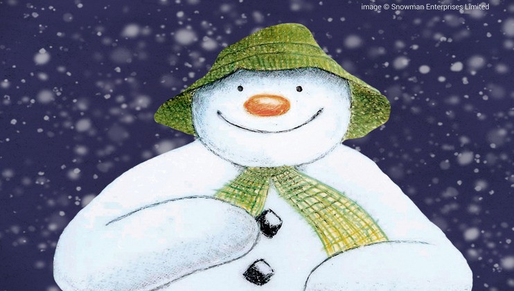 An illustrated snowman with a green hat and yellow scarf smiles warmly against a snowy night sky. The snowman has a carrot nose and is drawn in a soft, friendly style. Snowflakes fall gently around the figure, adding a festive, wintery feel.
