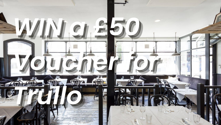 Interior of a modern restaurant with a text overlay that reads, WIN a £50 Voucher for Trullo. The restaurant has a clean, minimalist design with white tablecloths, black chairs, and large windows allowing natural light to fill the space.